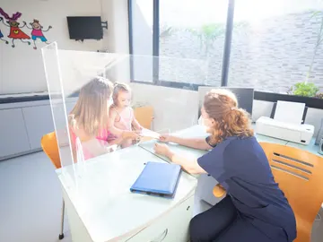 Una familia en una consulta de pediatria Una familia en una consulta de pediatria
