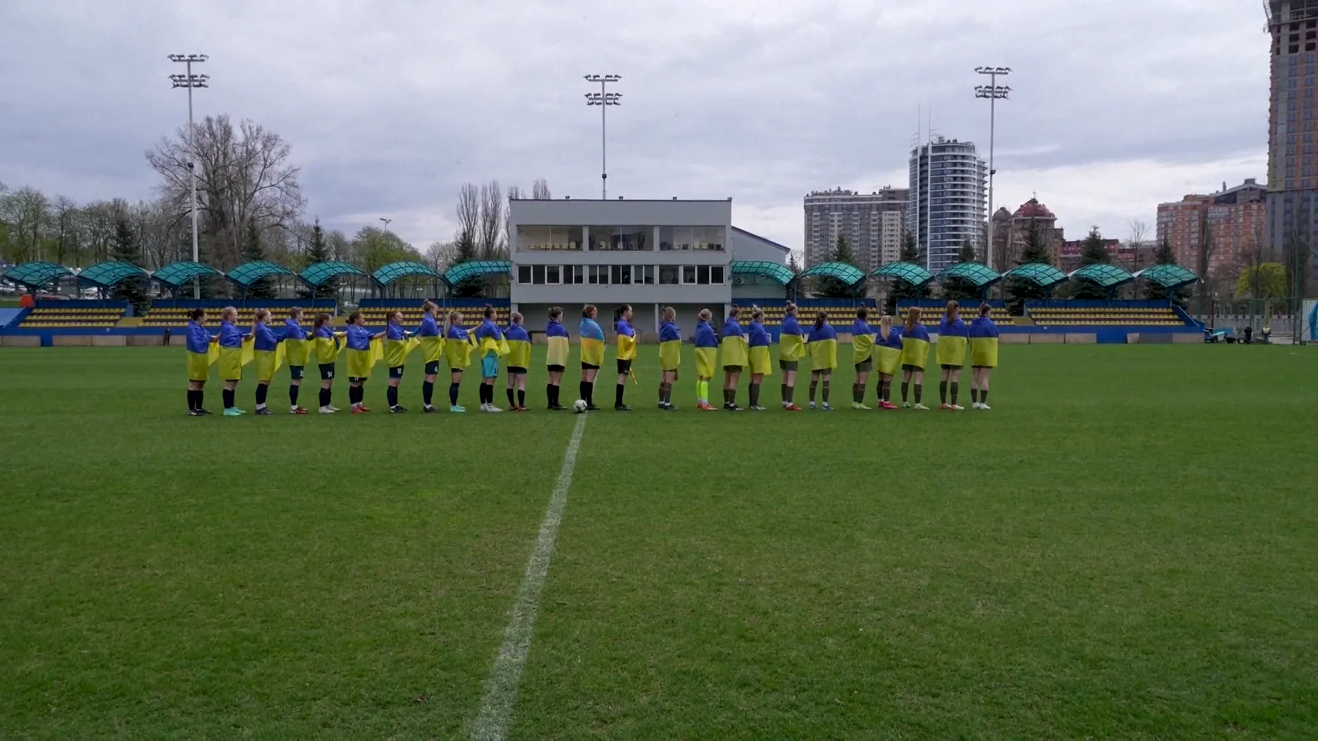 Las futbolistas del equipo de Mari&uacute;pol posan en el estadio con la bandera de Ucrania