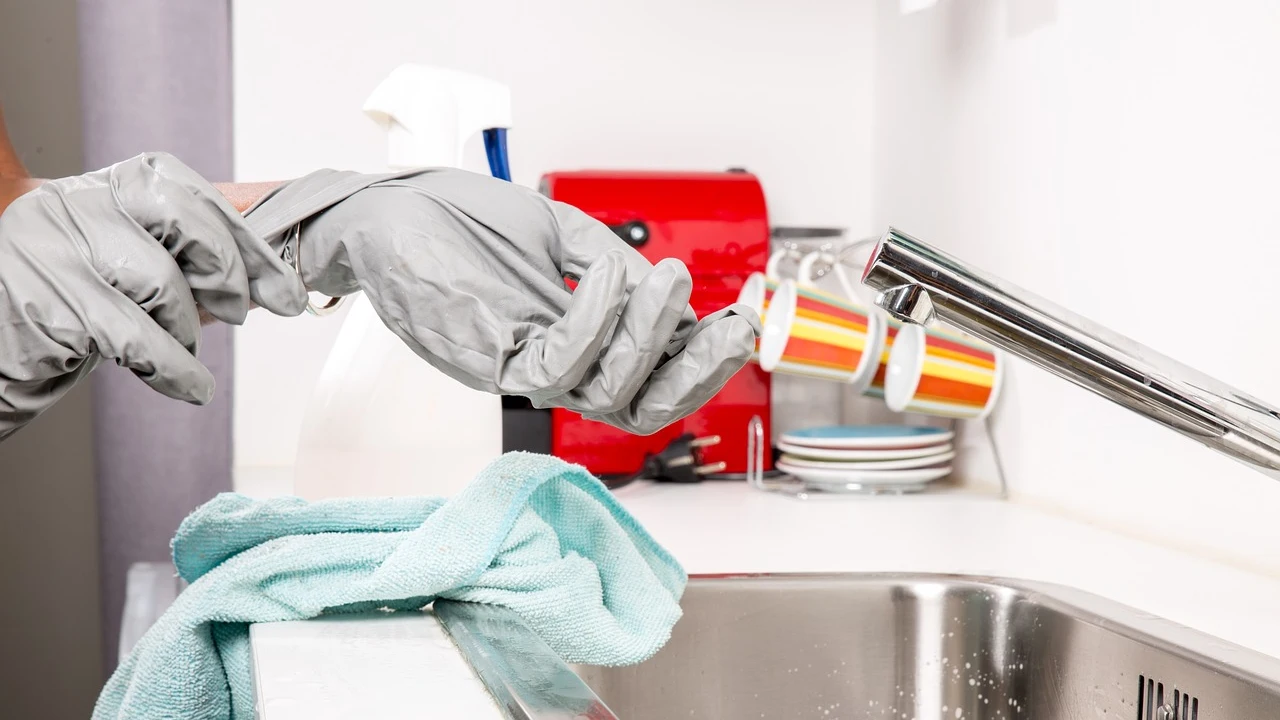 Persona se quita los guantes después de la limpieza Persona se quita los guantes después de la limpieza