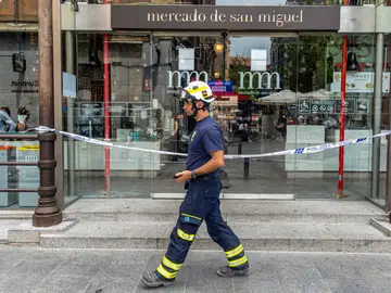 Un bombero pasa frente a la puerta del Mercado de San Miguel Un bombero pasa frente a la puerta del Mercado de San Miguel
