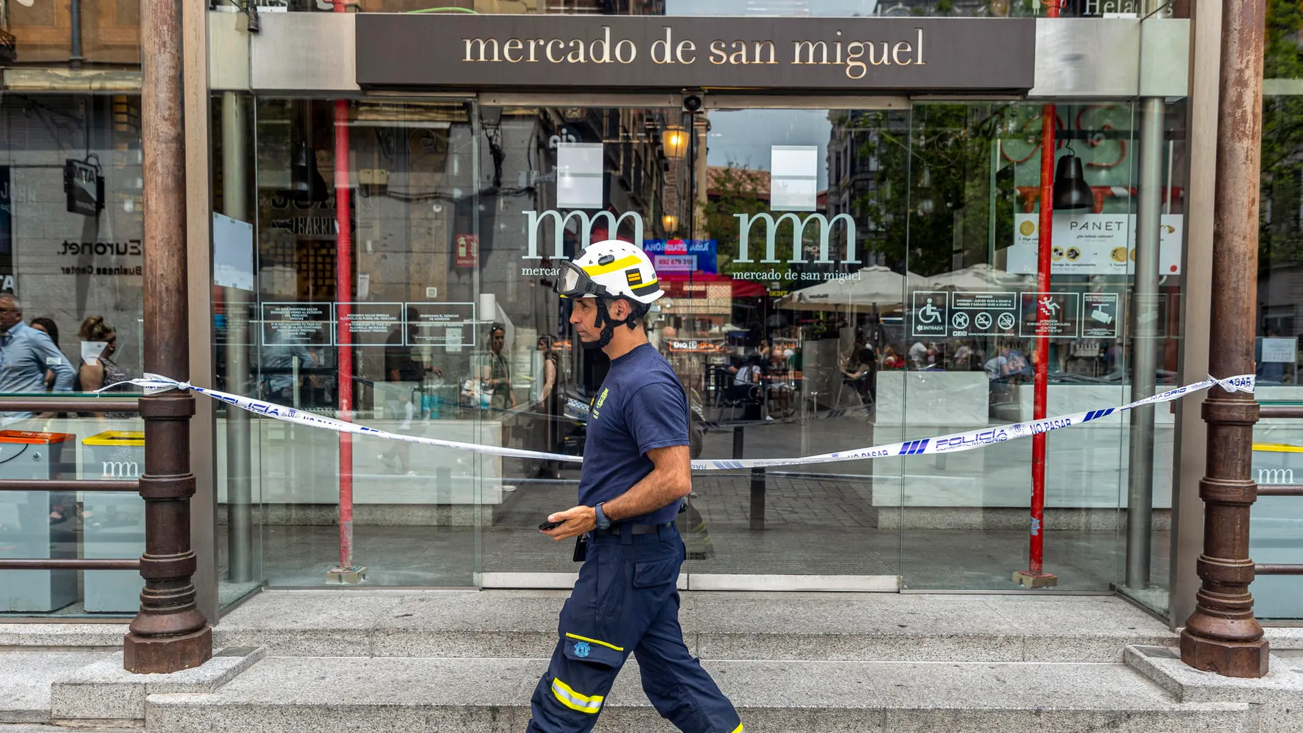Un bombero pasa frente a la puerta del Mercado de San Miguel