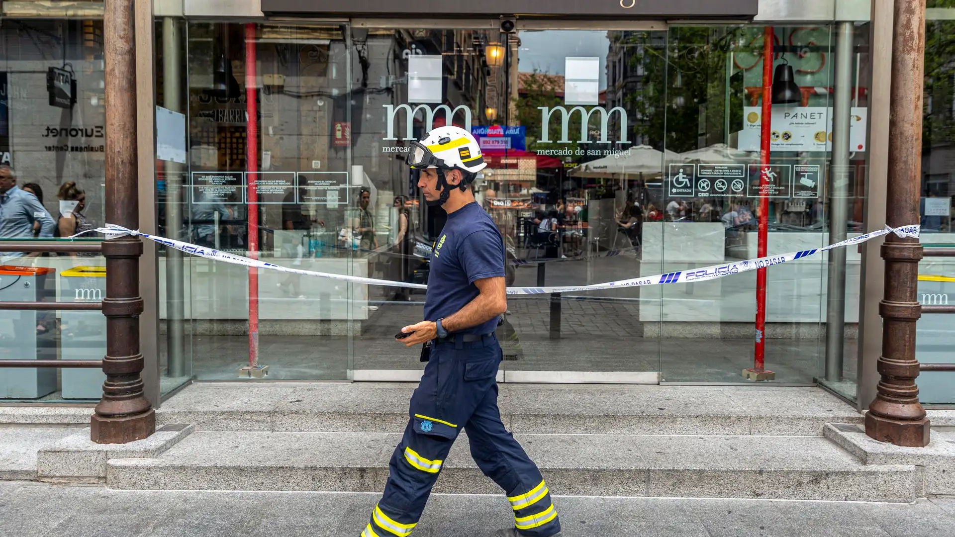 Un bombero pasa frente a la puerta del Mercado de San Miguel