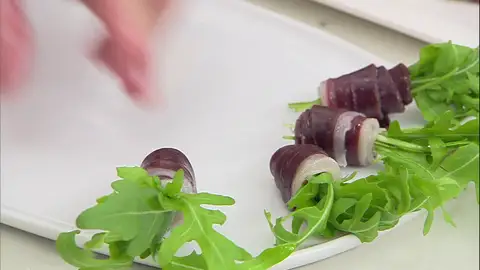 Enrolla el jamón alrededor de la rúcula Enrolla el jamón alrededor de la rúcula