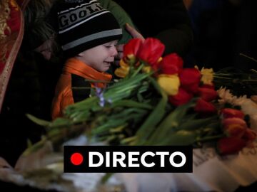 Mikhail, de 6 años, llora desconsoladamente ante los ataúdes de sus hermanos, Sofia y Kyrylo, muertos por el ataque ruso a Uman