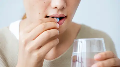 Una mujer tomando medicamentos