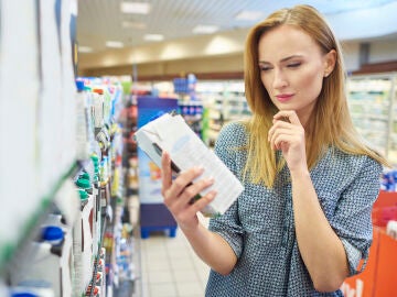 Una mujer revisa la etiqueta de un producto del supermercado