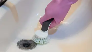 Persona limpiando sumidero 