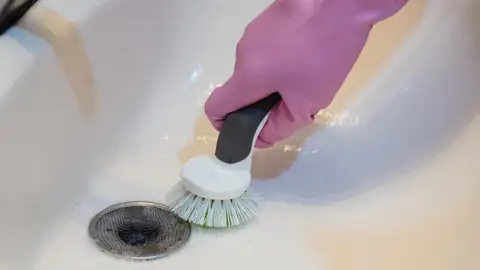 Persona limpiando sumidero Persona limpiando sumidero