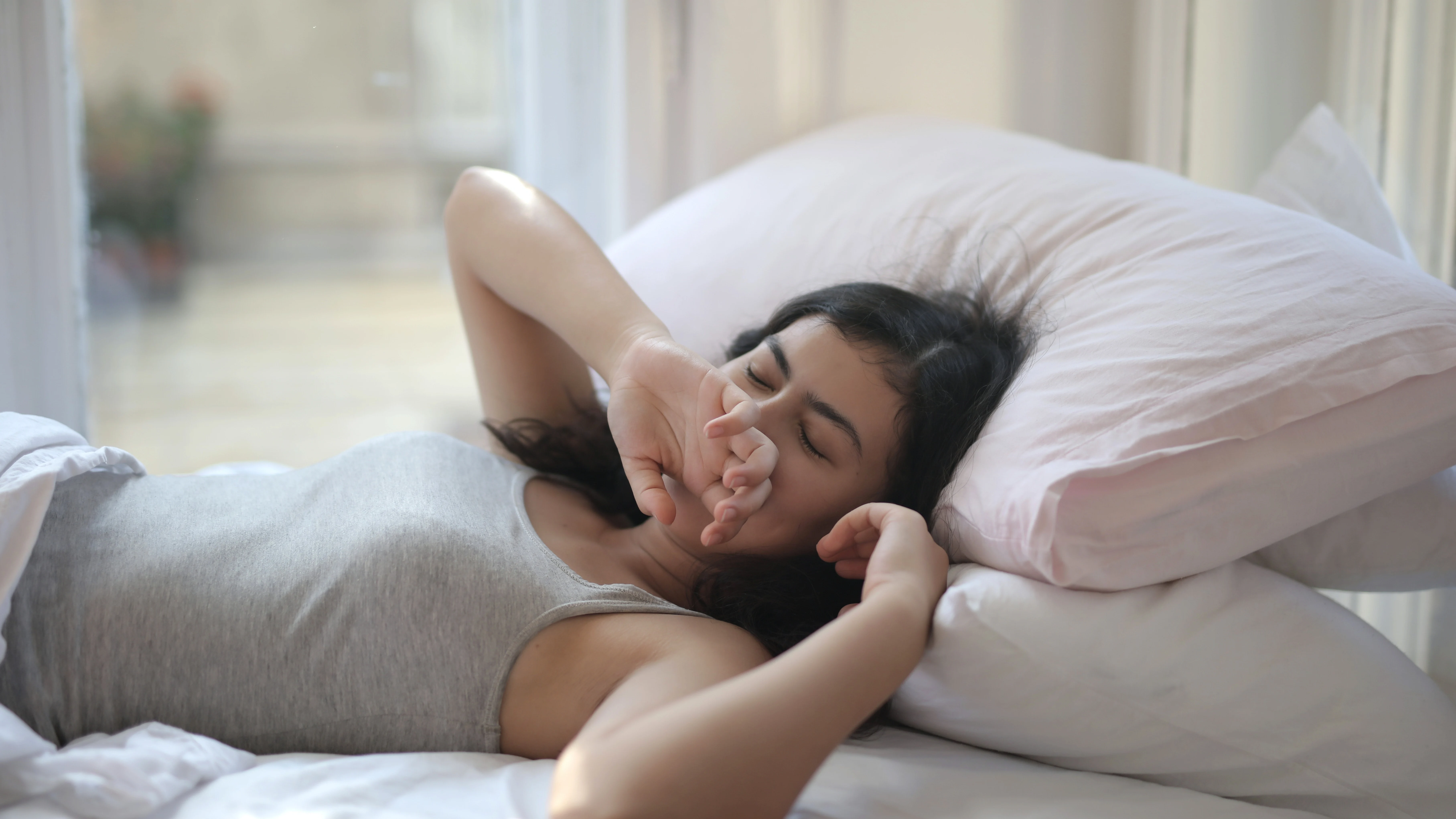 Mujer recostada sobre un par de almohadas