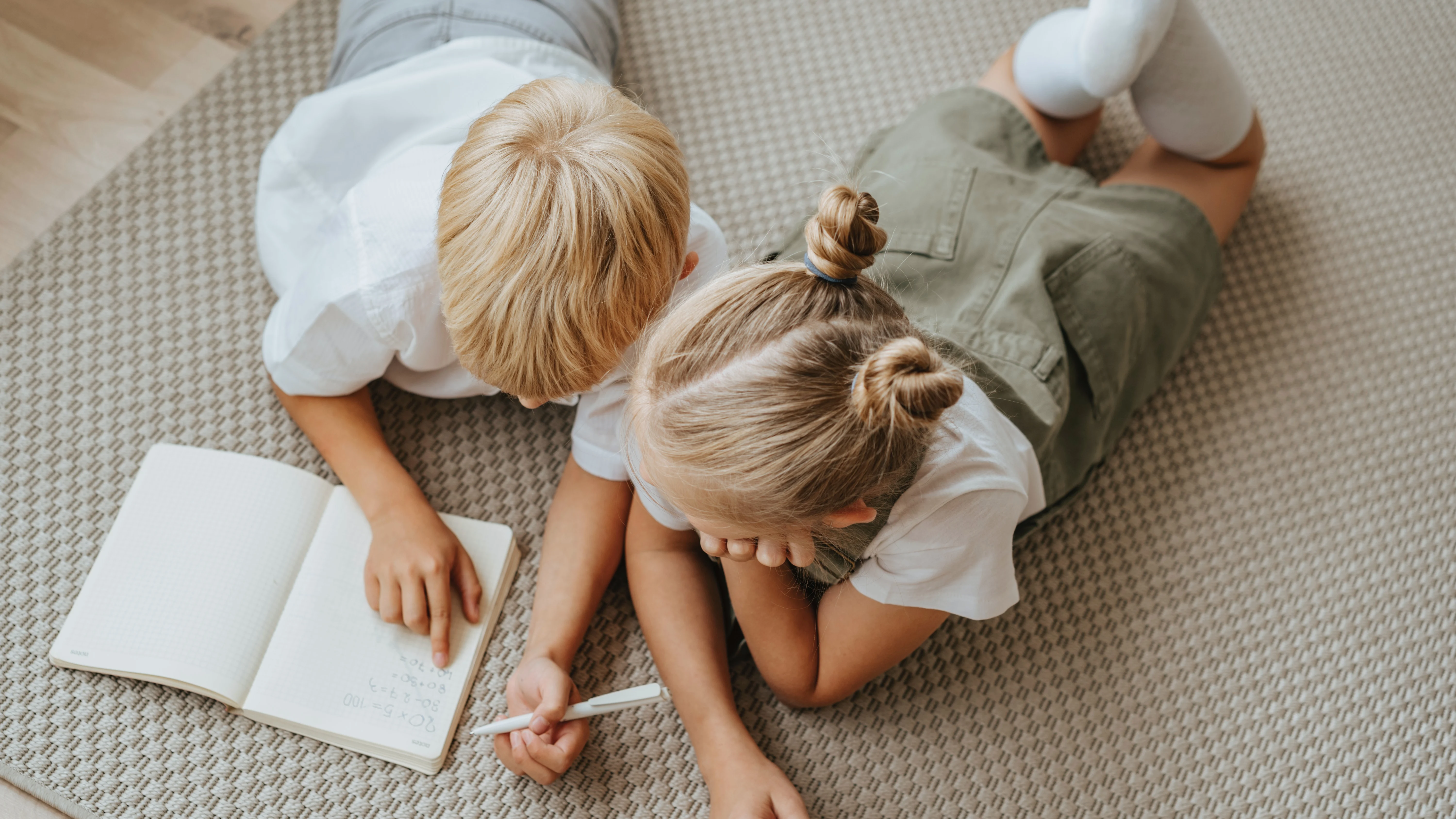 Dos niños escribiendo en una libreta Dos niños escribiendo en una libreta