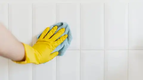 Lavando las juntas de las baldosas de la pared del baño Lavando las juntas de las baldosas de la pared del baño