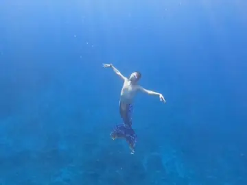 Un hombre practica mermaiding en el mar Un hombre practica mermaiding en el mar