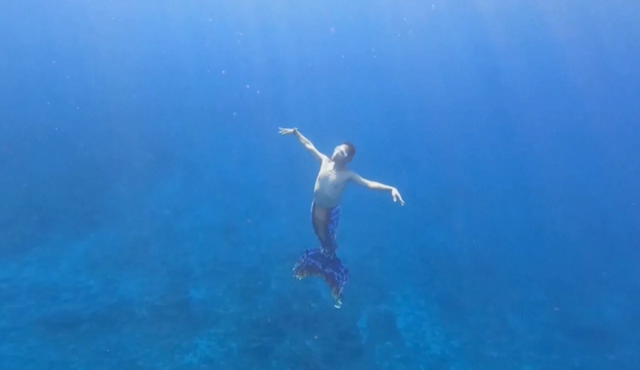 Un hombre practica mermaiding en el mar