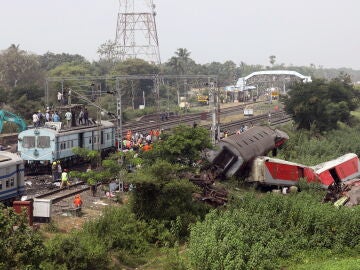 Trabajadores de tierra del ferrocarril indio instalan nuevas vías de tren en el lugar de un accidente de tren en Odisha Balasore, India