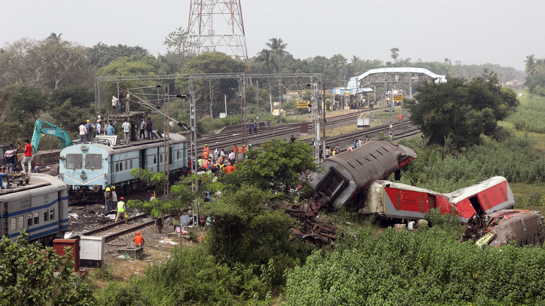 Trabajadores de tierra del ferrocarril indio instalan nuevas vías de tren en el lugar de un accidente de tren en Odisha Balasore, India