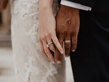Dos novios se cogen de la mano en su boda Dos novios se cogen de la mano en su boda