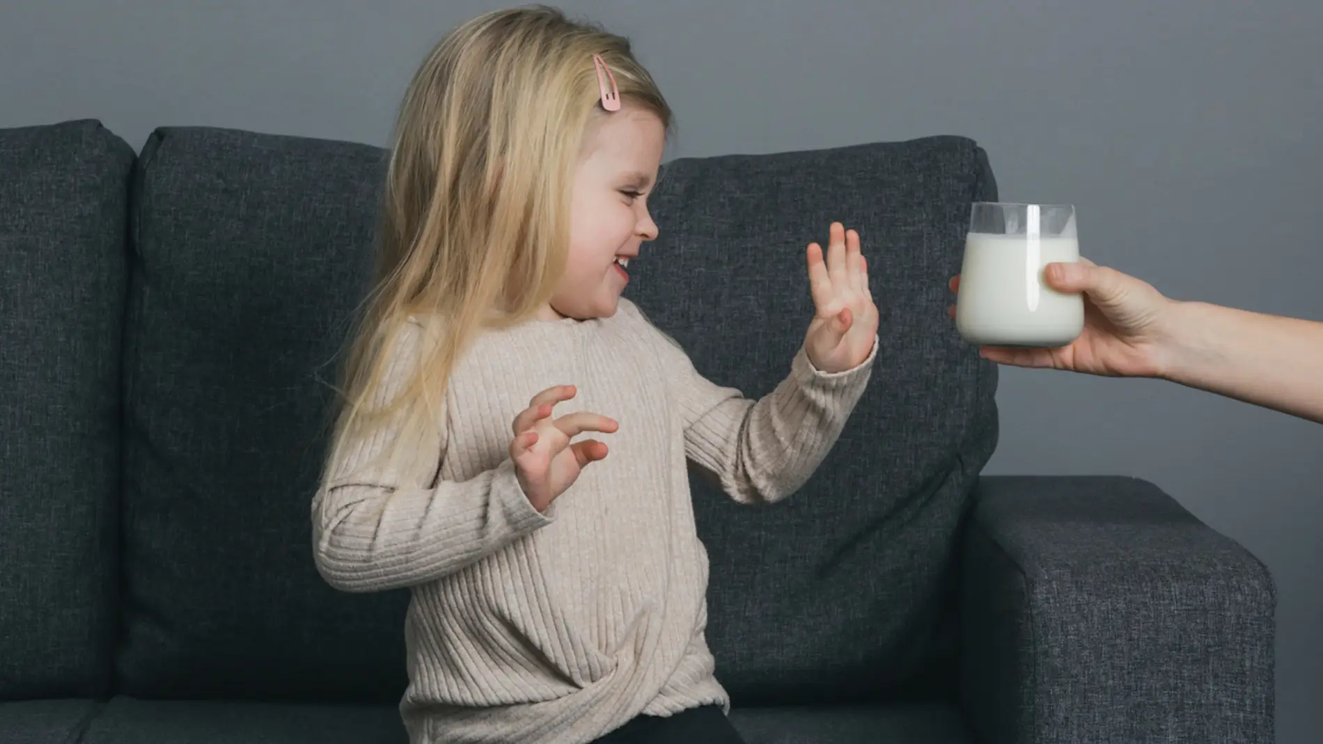 Una niña rechaza un vaso de leche