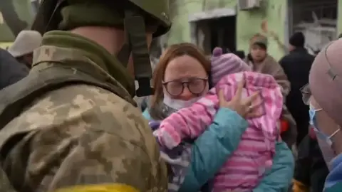 Un soldado junto a una mujer y su hija Un soldado junto a una mujer y su hija