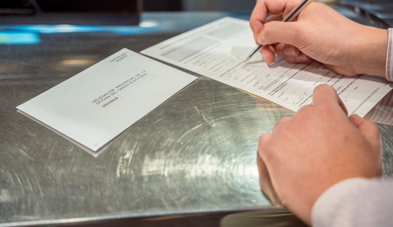 Una persona rellenado el voto por correo