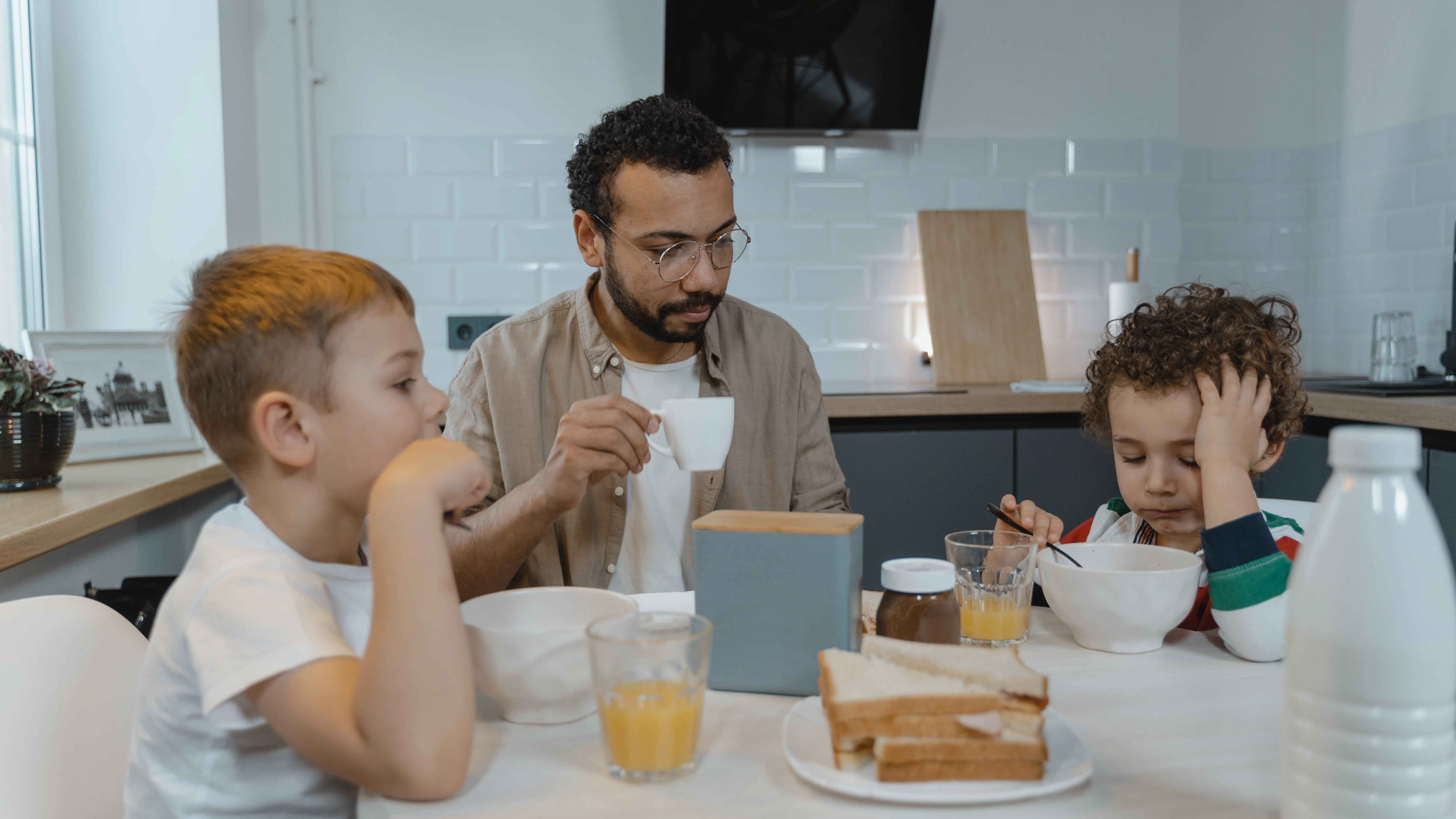 Padre e hijos desayunando Padre e hijos desayunando