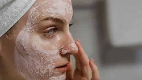Mujer aplicándose cosméticos Mujer aplicándose cosméticos