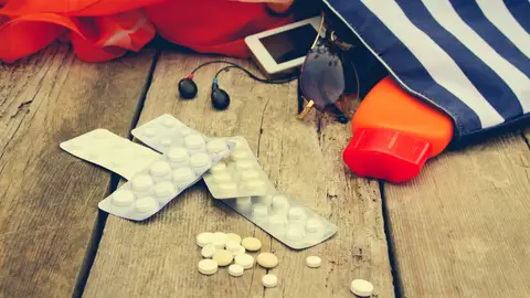 Medicamentos saliendo de un bolso de playa Medicamentos saliendo de un bolso de playa
