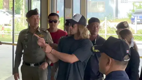 Una foto proporcionada por la Policía Real de Tailandia muestra a un chef español, sospechoso de asesinato Daniel Jeronimo Sancho Bronchalo, (C) es escoltado por policías tailandeses durante una recreación del crimen 