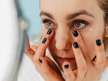Primer plano de una mujer aplicándose una crema Primer plano de una mujer aplicándose una crema