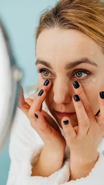 Primer plano de una mujer aplicándose una crema Primer plano de una mujer aplicándose una crema