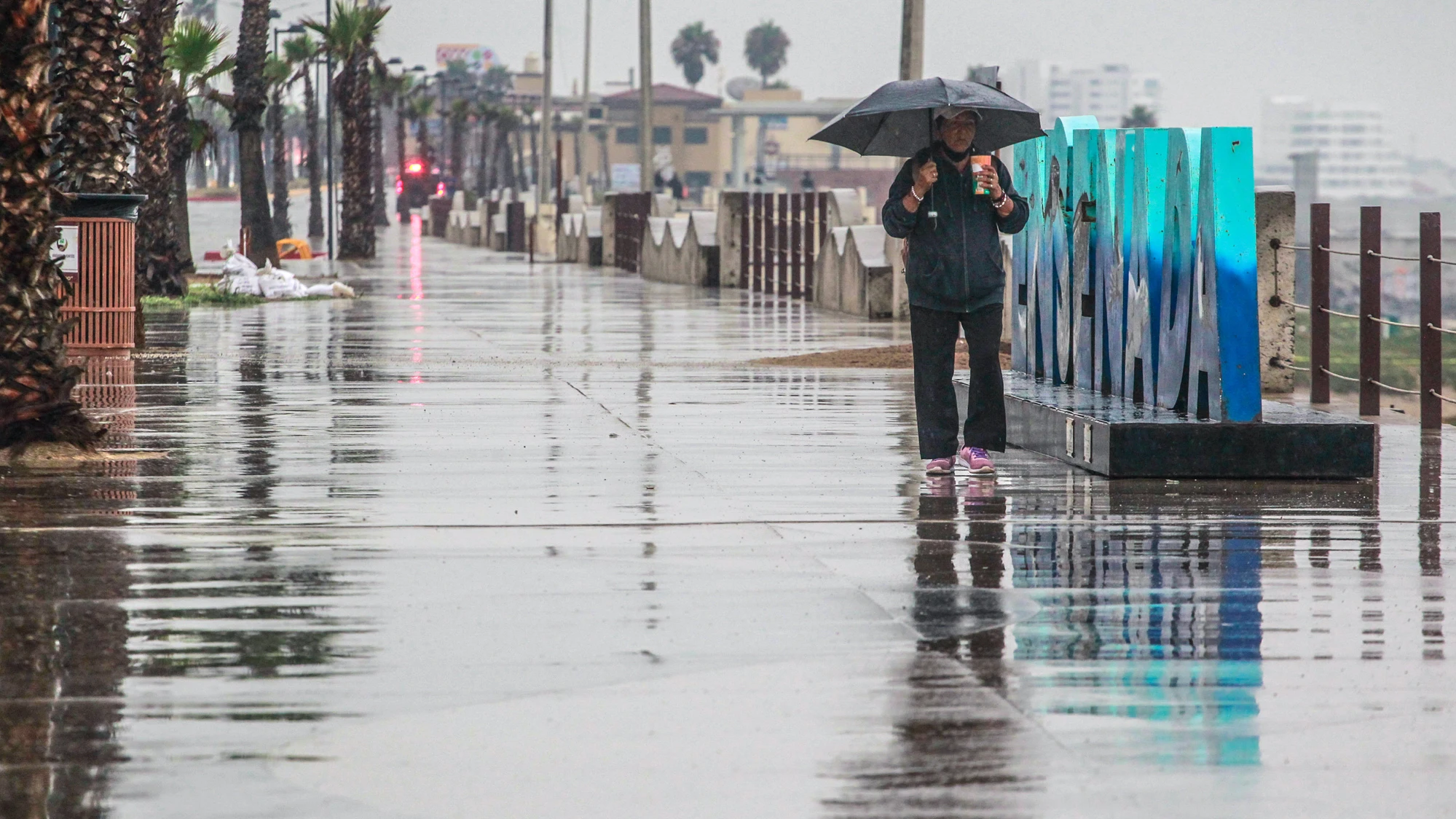 Una persona camina bajo la lluvia hoy, en el puerto de Ensenada en Baja California (México) Una persona camina bajo la lluvia hoy, en el puerto de Ensenada en Baja California (México)