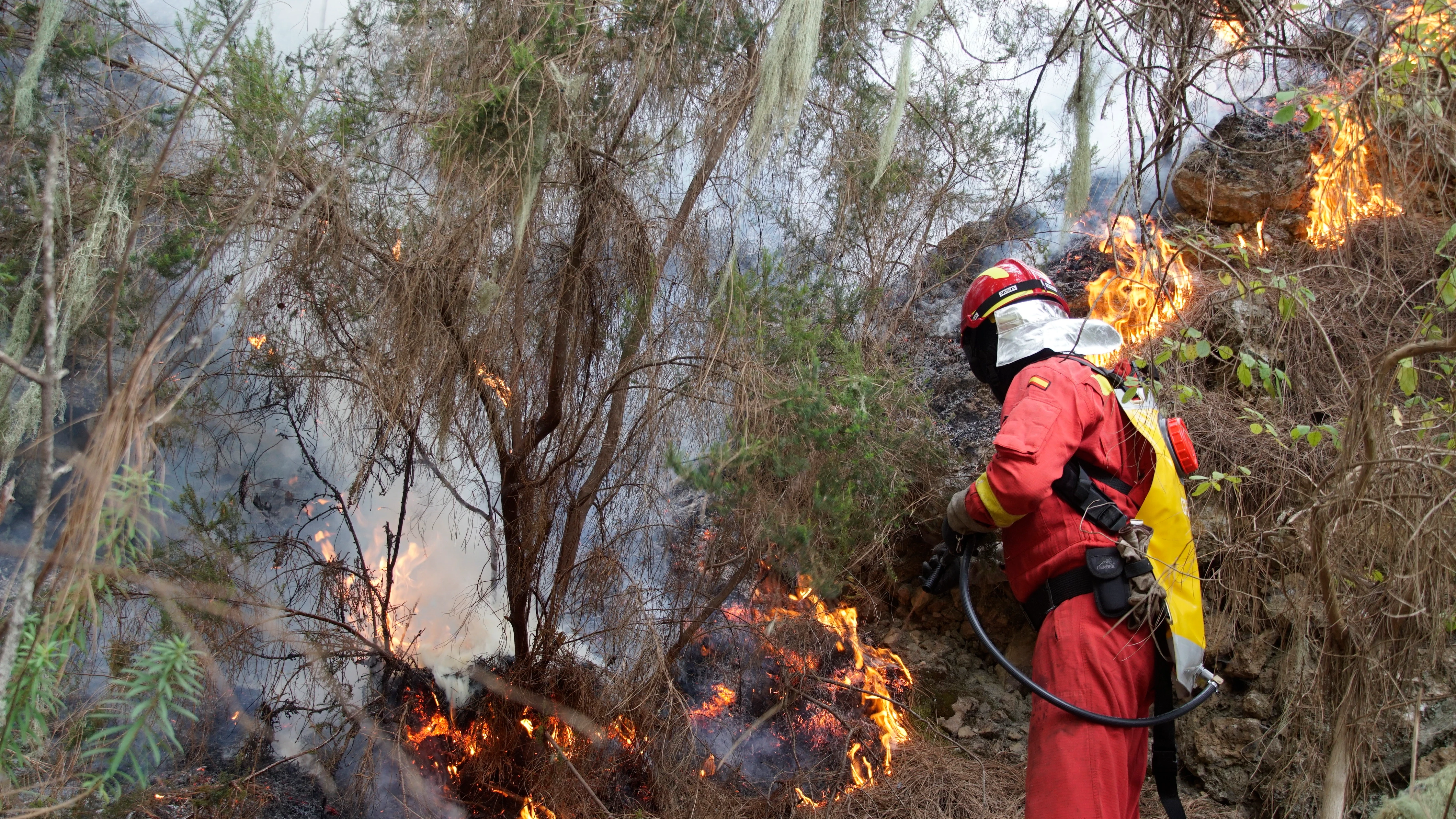 Imagen de un bombero tratando de apagar el fuego de Tenerife