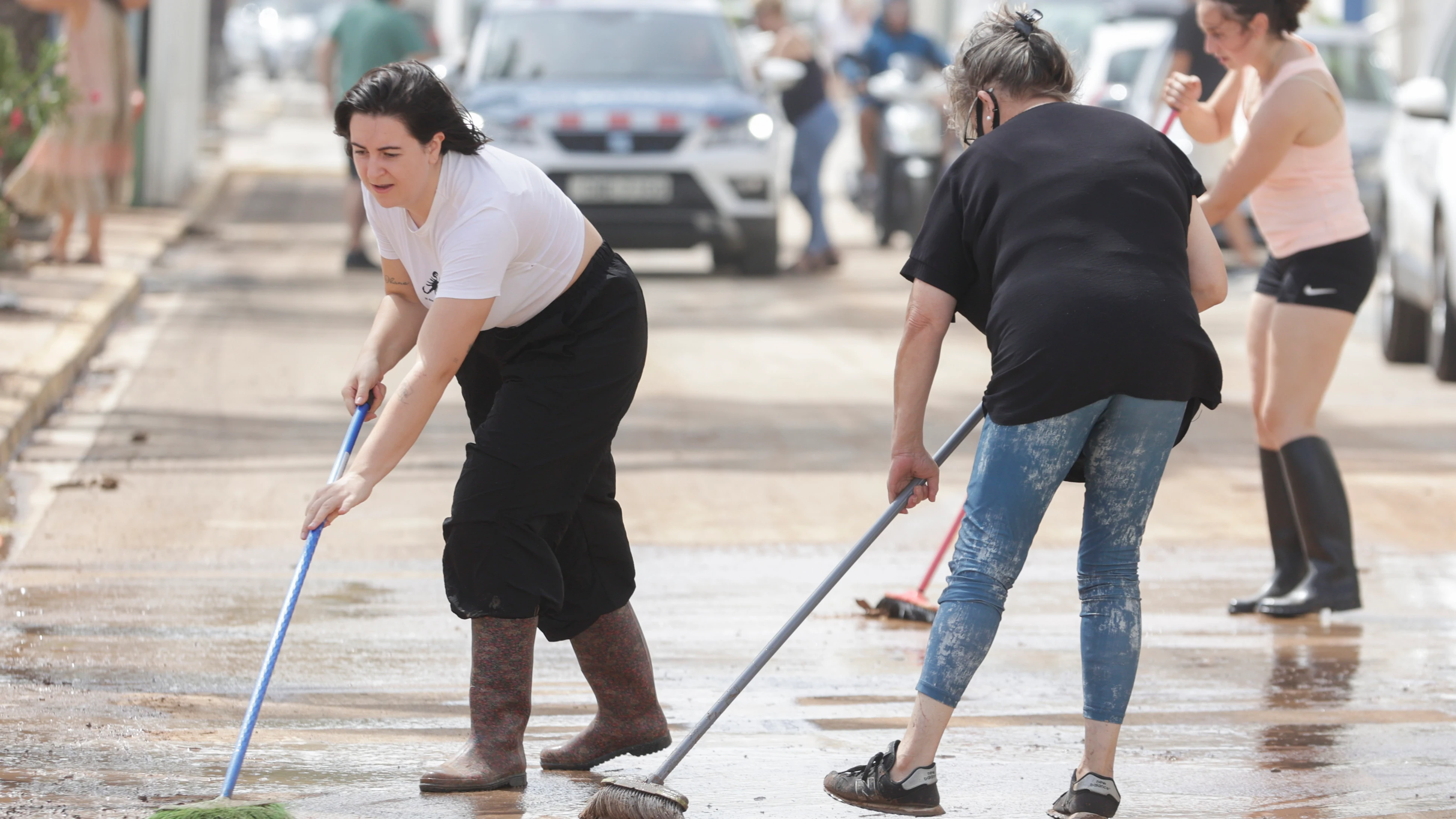 Imagen de archivo de varias personas barriendo el barro en las calles Imagen de archivo de varias personas barriendo el barro en las calles