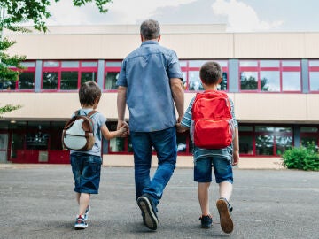 Padre acompañando a sus hijos al colegio