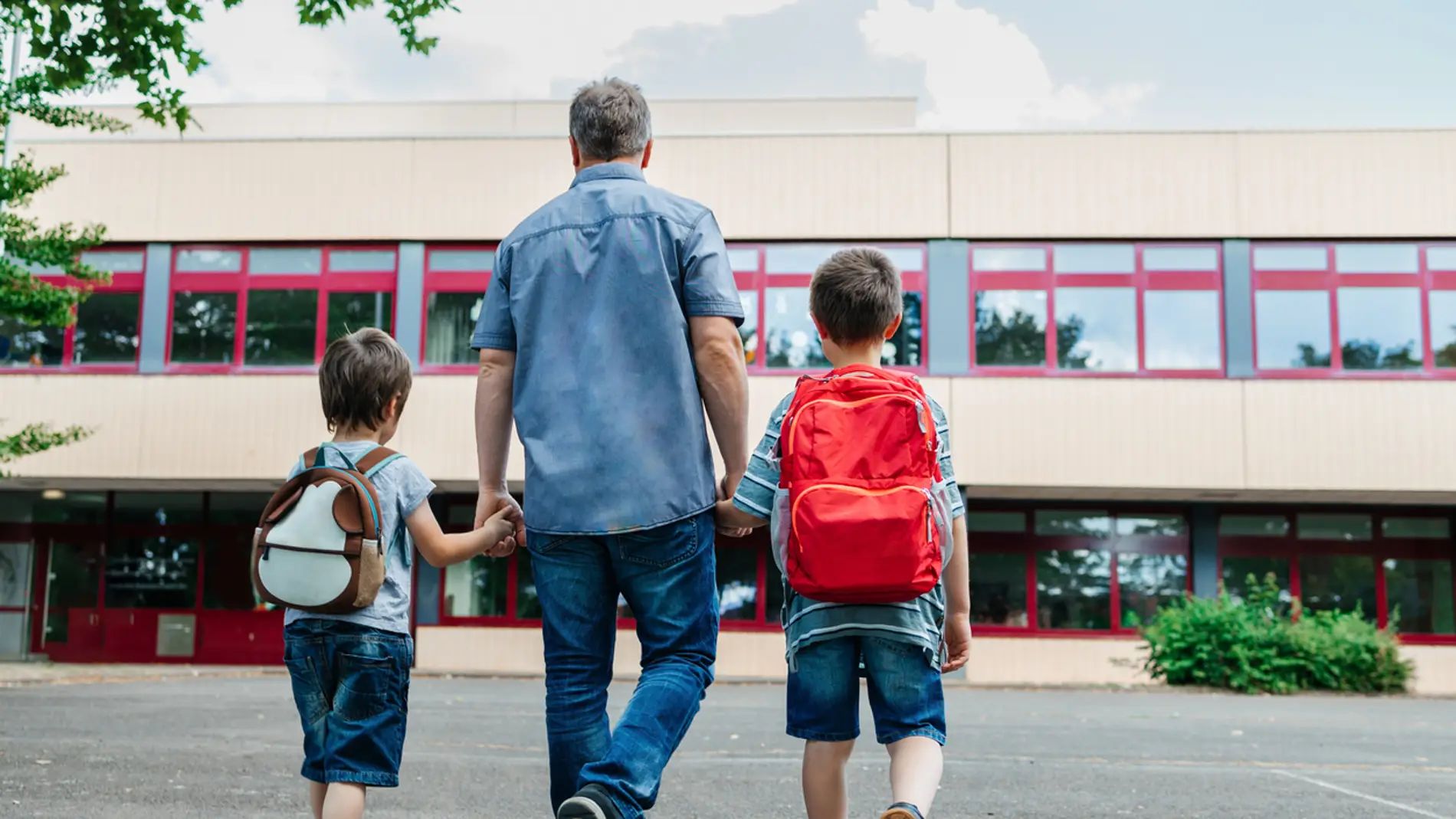 Padre acompañando a sus hijos al colegio