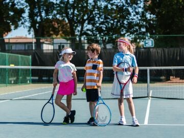 Niñas y niño jugando a tenis