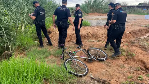 La Policía Local de paterna junto a la bicicleta del hombre arrastrado por el agua que intentó cruzar un barranco en Paterna. La Policía Local de paterna junto a la bicicleta del hombre arrastrado por el agua que intentó cruzar un barranco en Paterna.