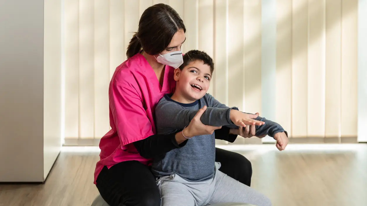 Un niño con parálisis cerebral recibiendo terapia Un niño con parálisis cerebral recibiendo terapia