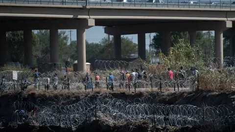Un grupo de migrantes camina del lado de Estados Unidos Un grupo de migrantes camina del lado de Estados Unidos