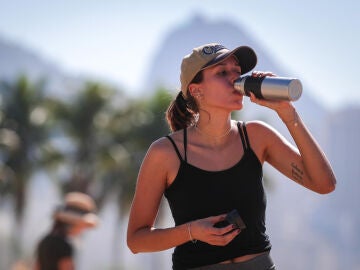 Una joven bebe agua por el intenso calor