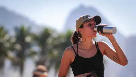 Una joven bebe agua por el intenso calor Una joven bebe agua por el intenso calor