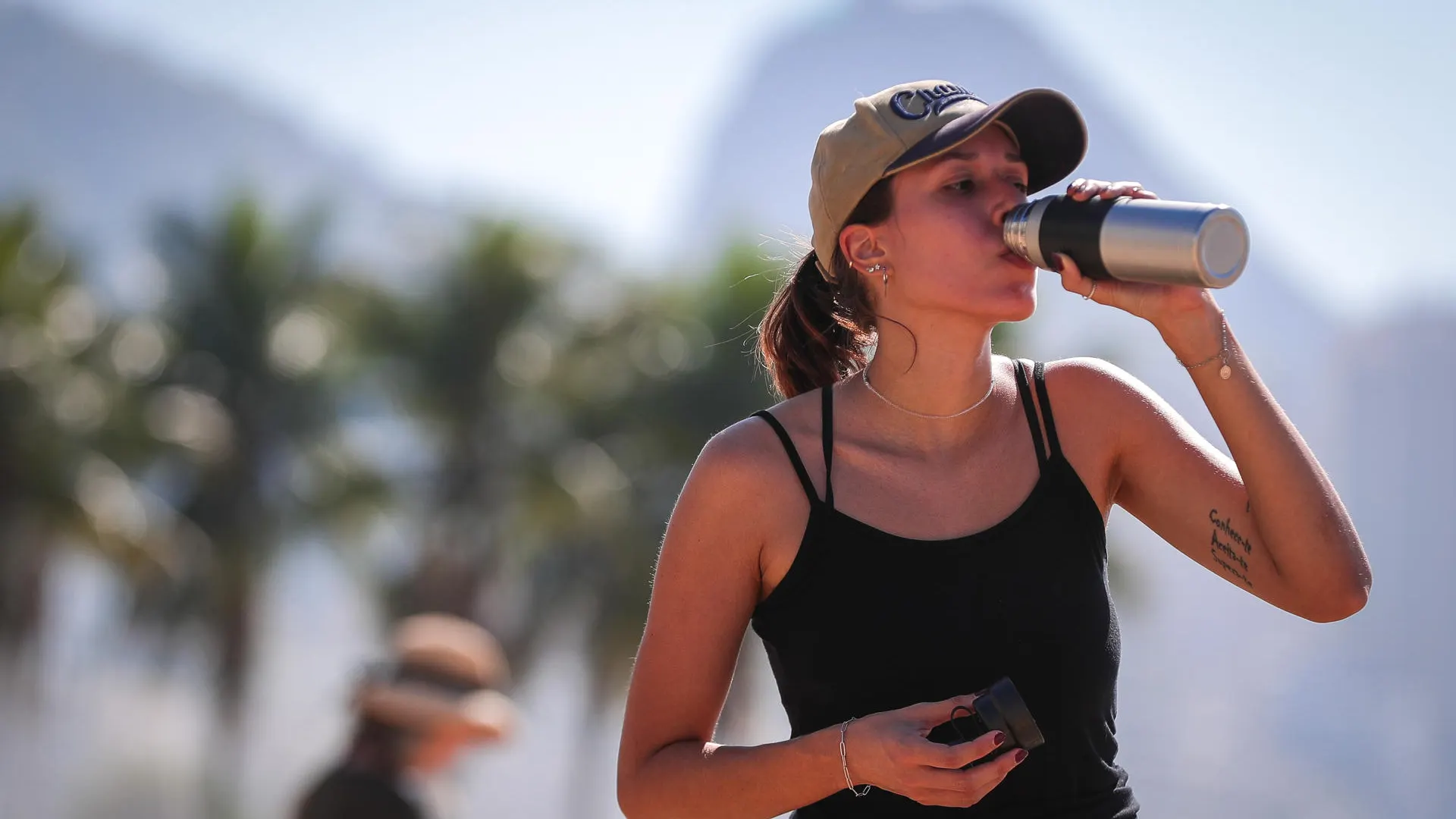 Una joven bebe agua por el intenso calor Una joven bebe agua por el intenso calor
