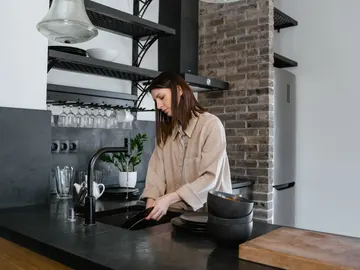 Mujer limpiando los platos Mujer limpiando los platos