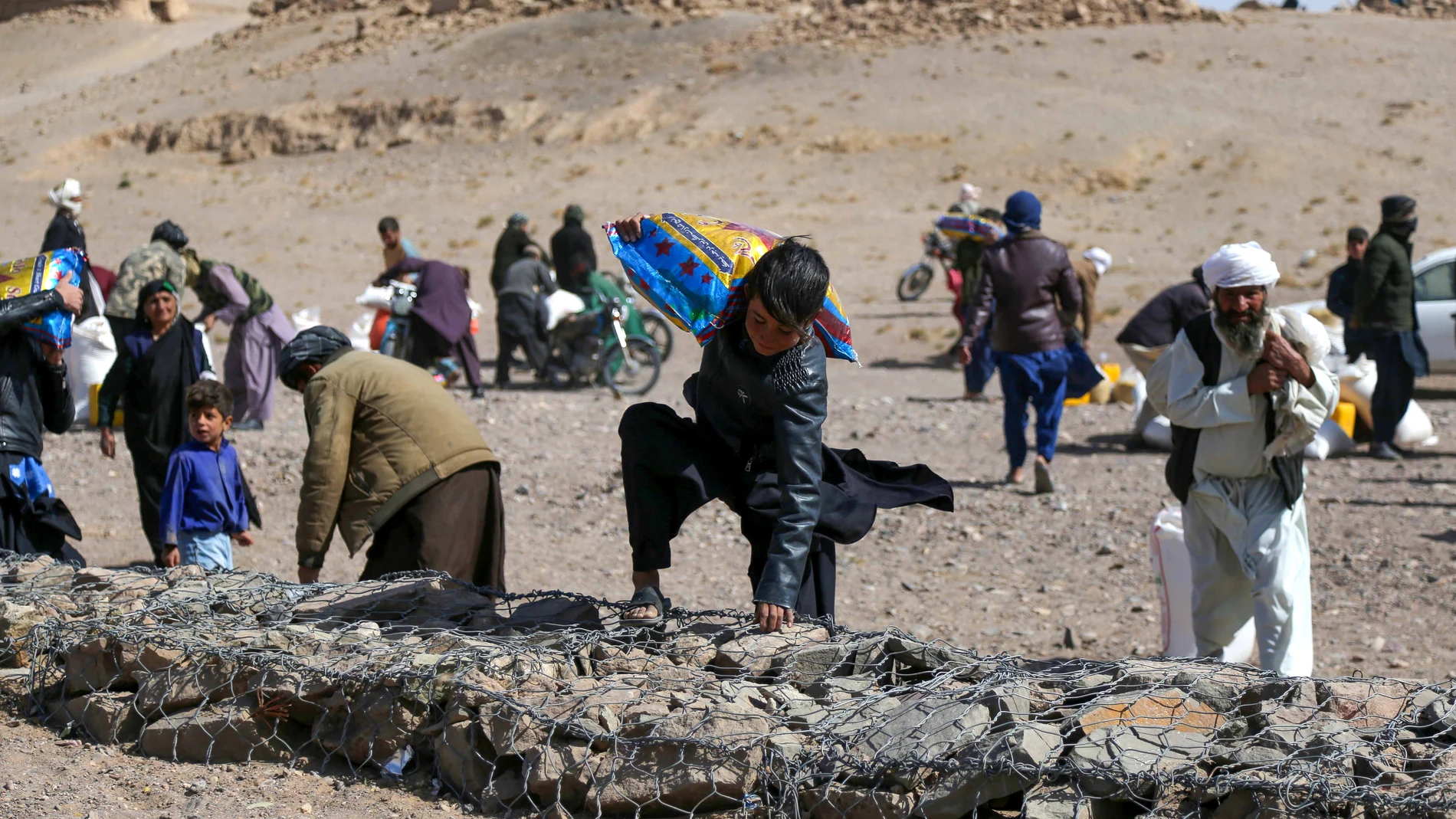 Un grupo de personas traslada sus pertenencias tras los terremotos en el distrito de Herat