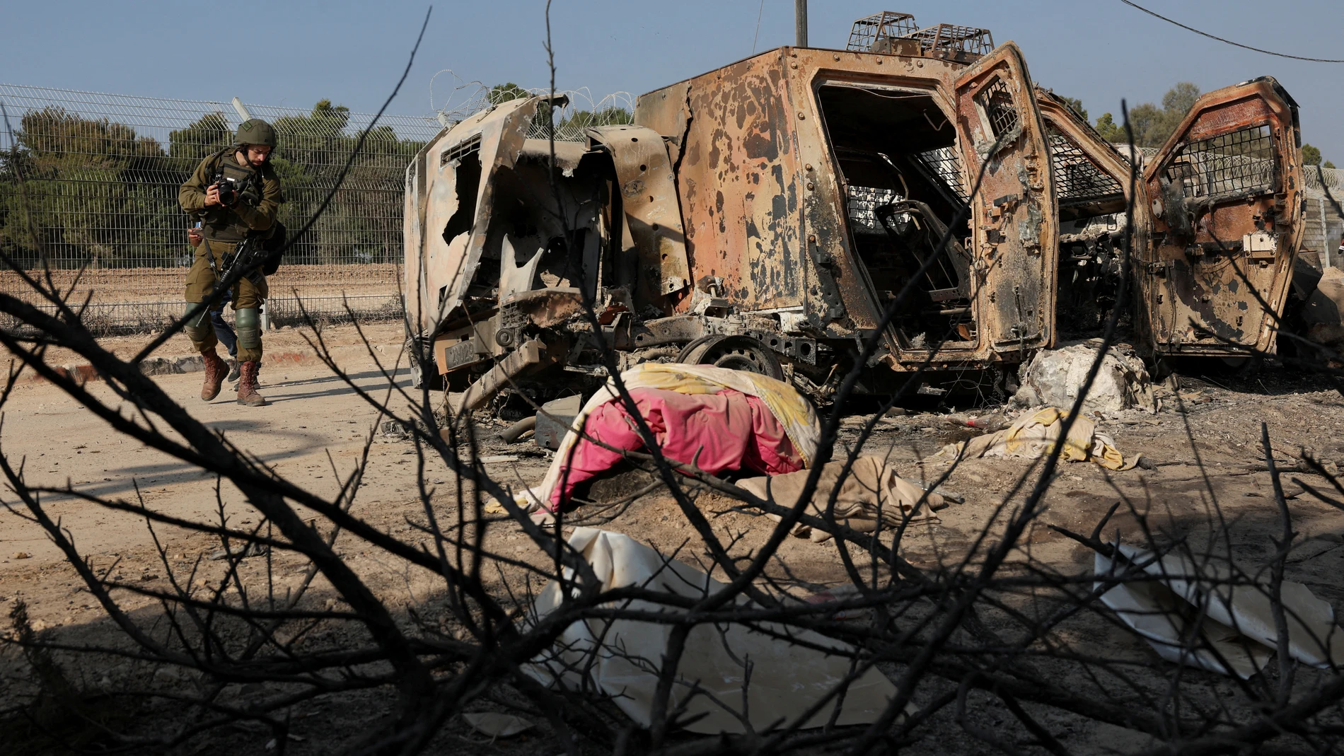 Un soldado israelí camina junto a un vehículo averiado en Gaza