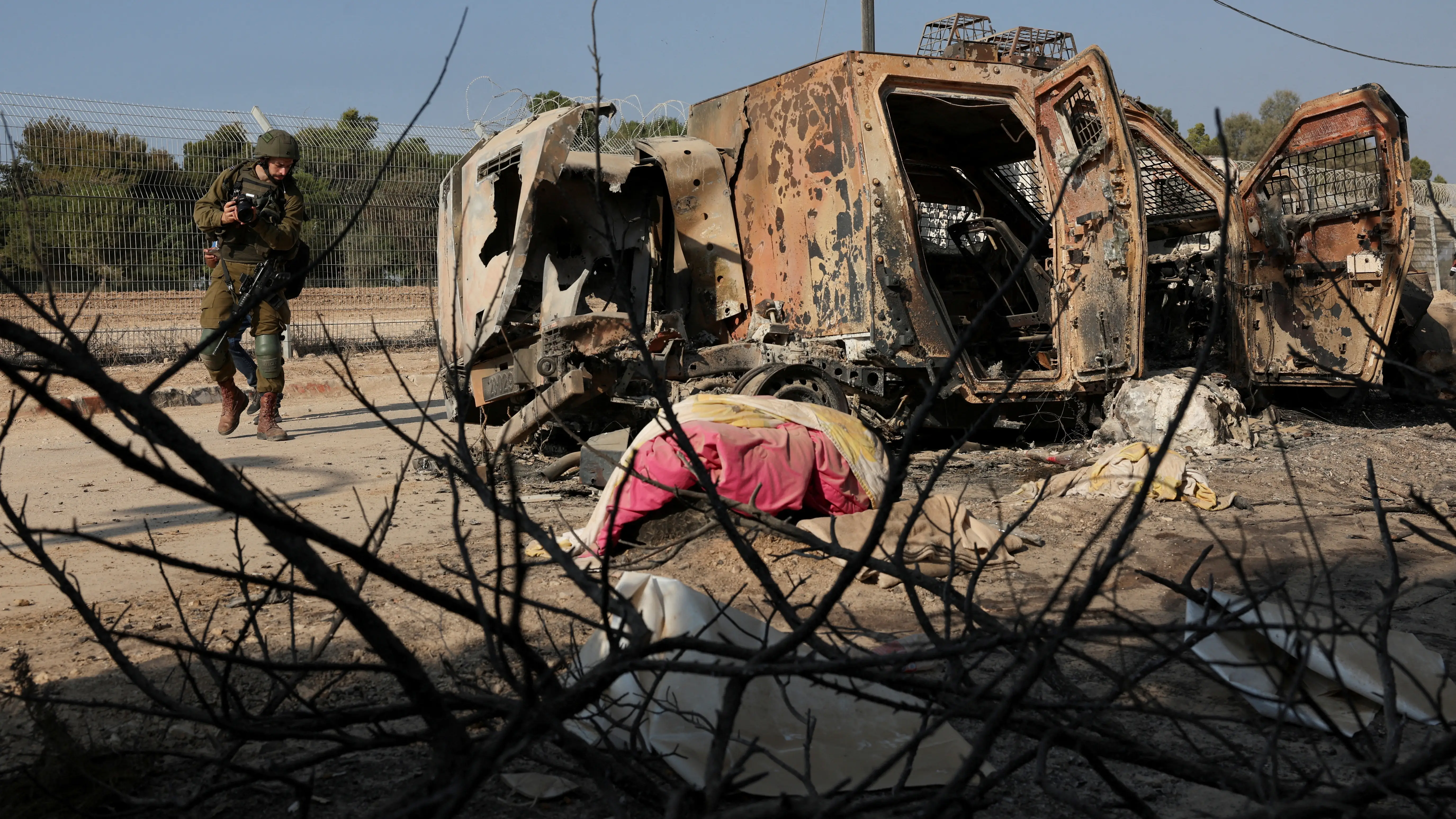 Un soldado israel&iacute; camina junto a un veh&iacute;culo averiado en Gaza