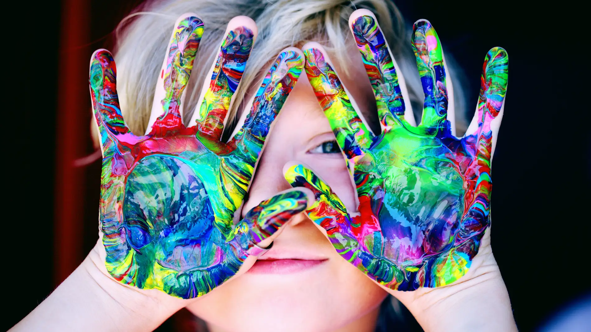 Un niño con las manos llenas de pintura.