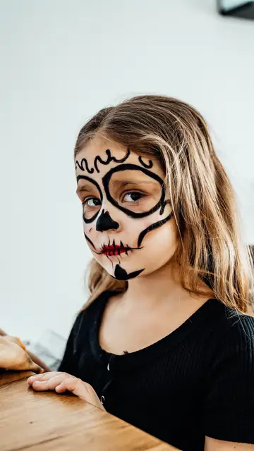 Niña con la cara pintada de Halloween Niña con la cara pintada de Halloween