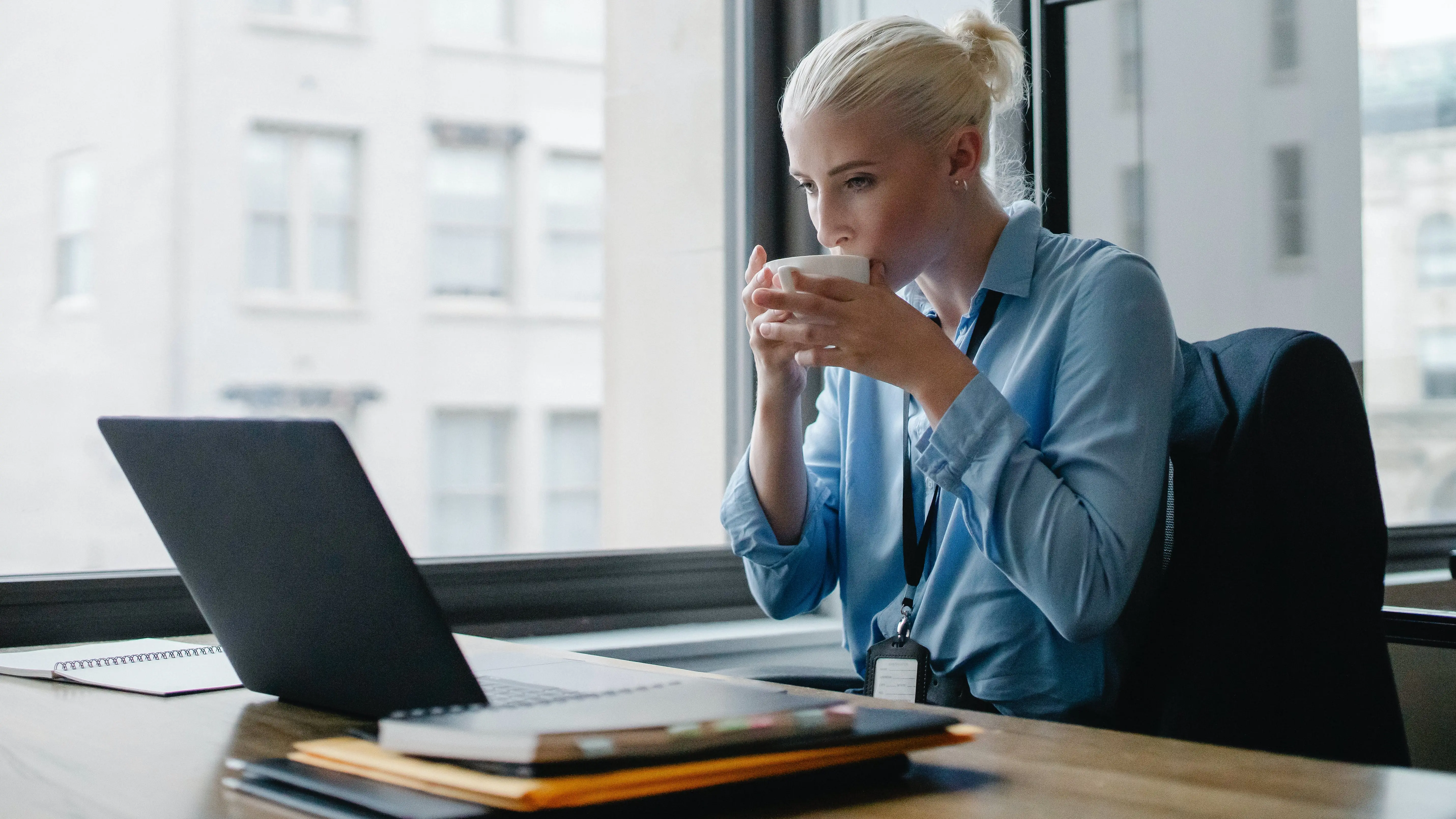 Mujer bebiendo de una taza delante del ordenador Mujer bebiendo de una taza delante del ordenador