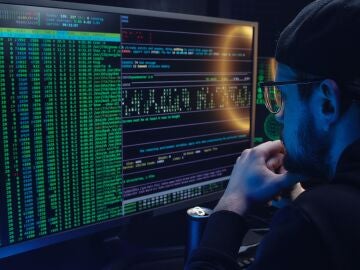 Hombre observando códigos en un ordenador
