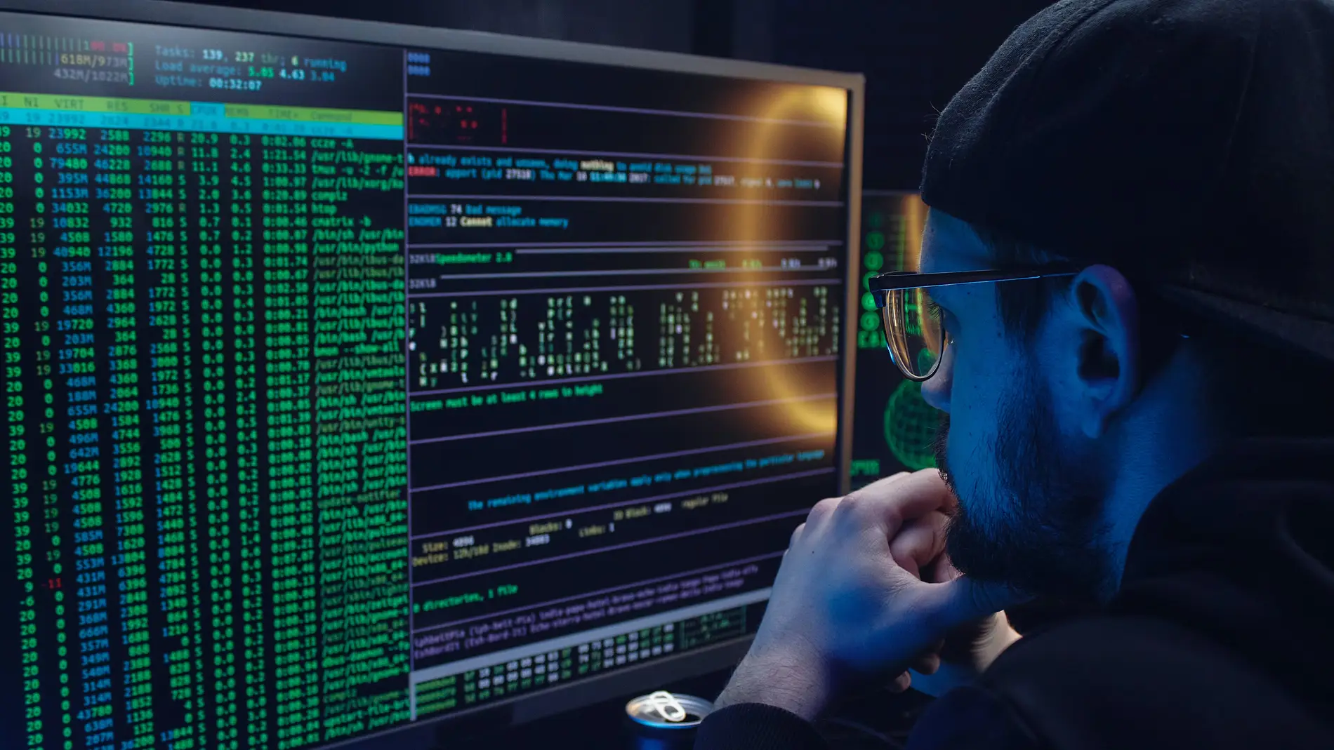 Hombre observando códigos en un ordenador